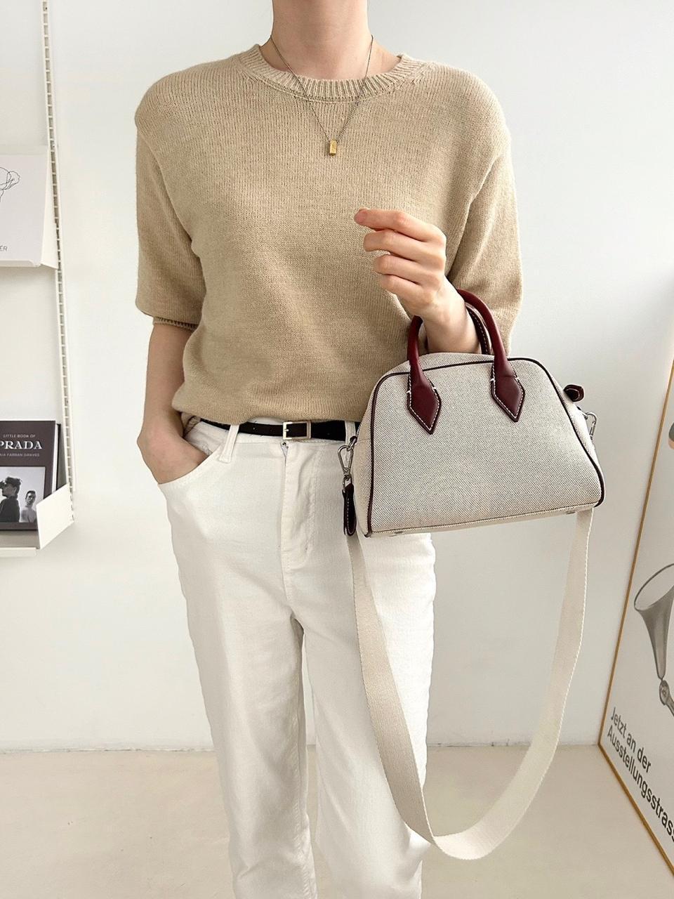 dome-shaped handbag with a cream canvas body and dark brown leather handles