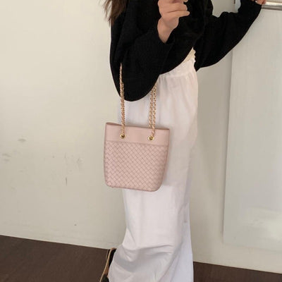 Elegant Pink woven leather bag with gold chain strap.