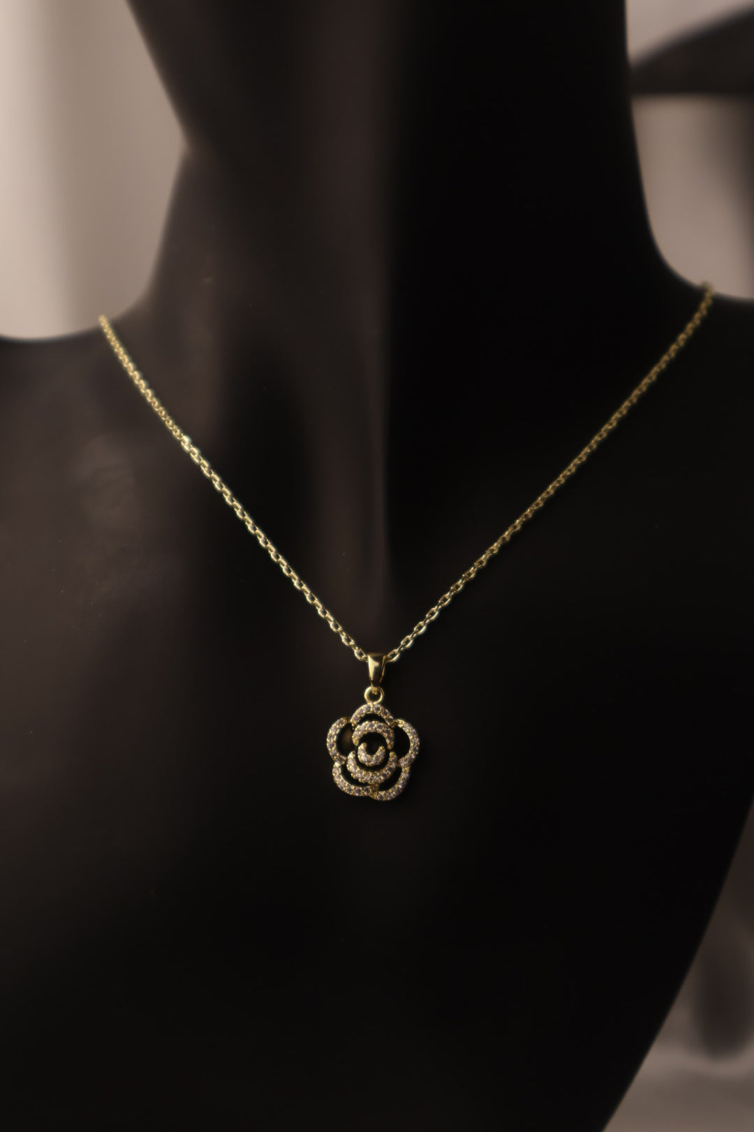 gold chain with black flower pendent